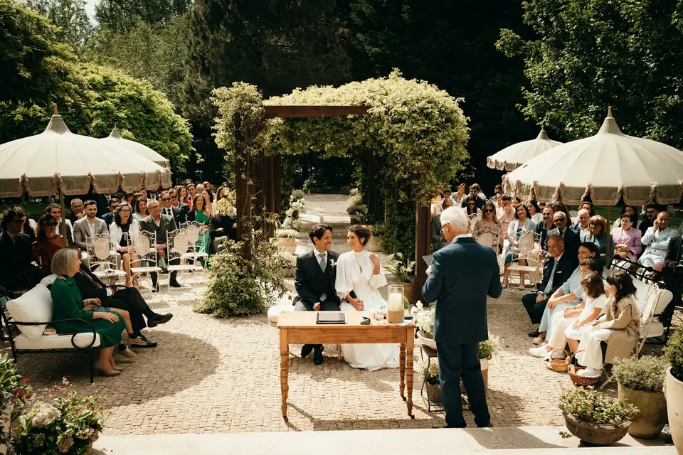 Guests seated for an outdoor garden ceremony under the trees