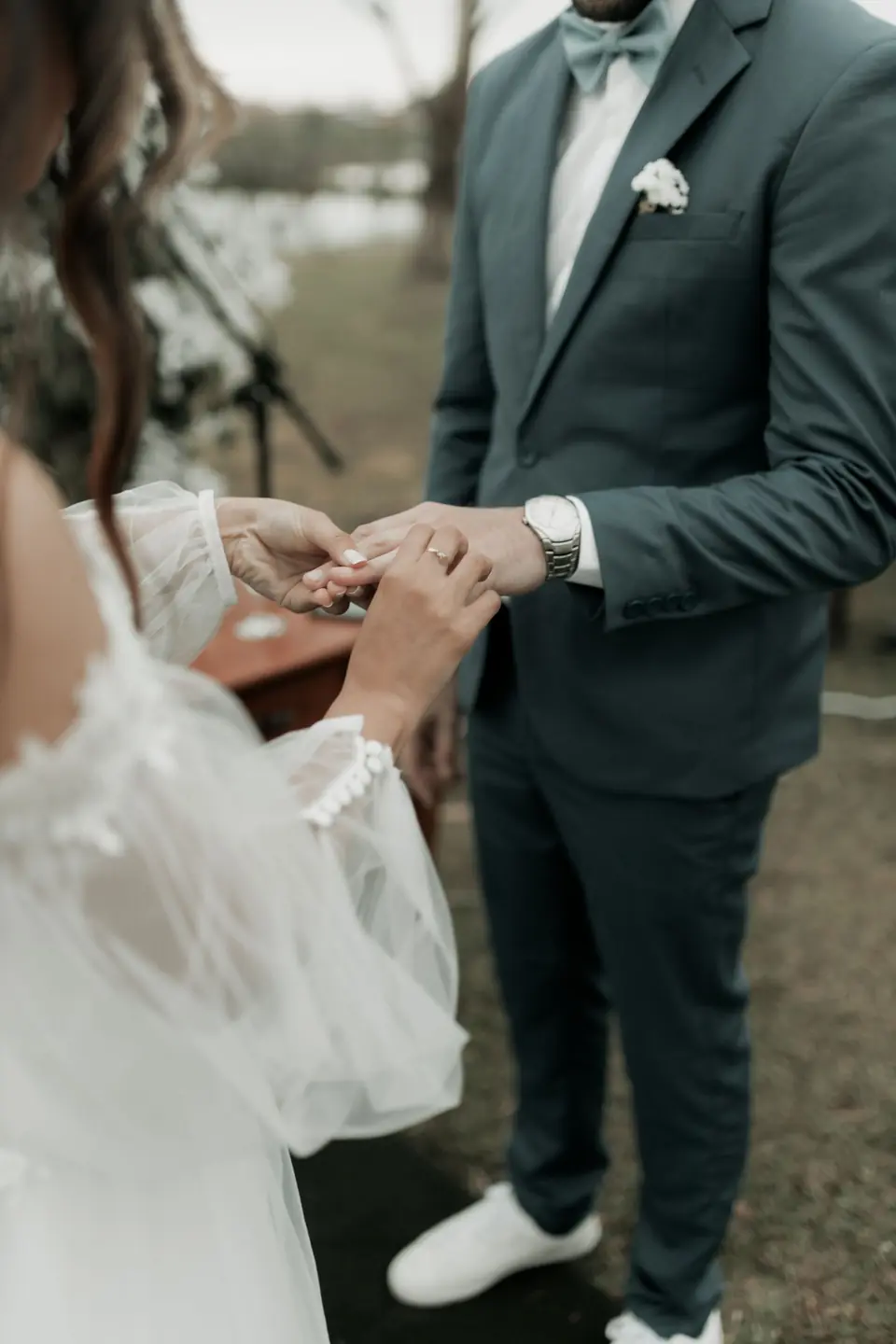 A groom placing a ring on the bride's finger during the ceremony