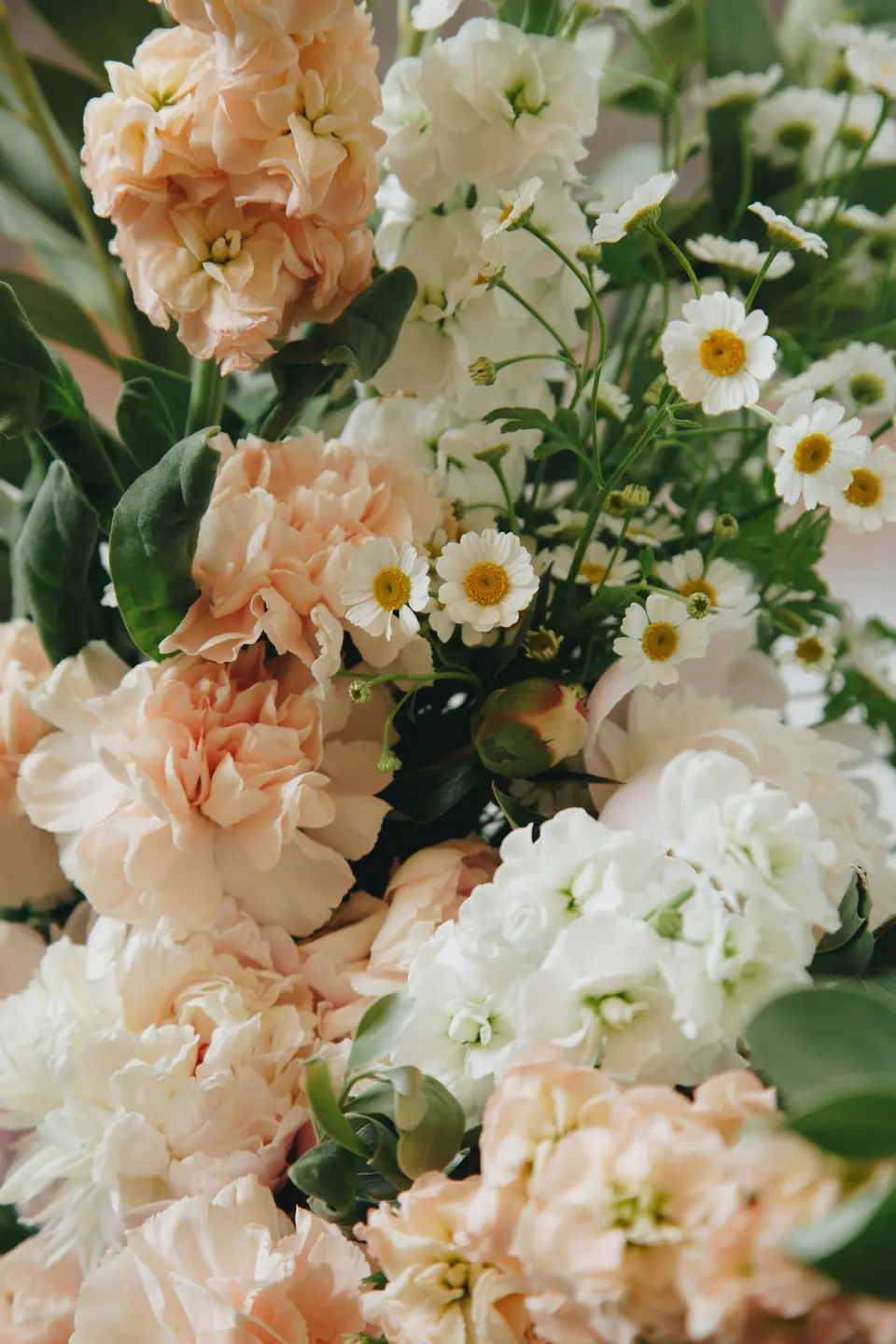 A lush arrangement of peach and white garden flowers