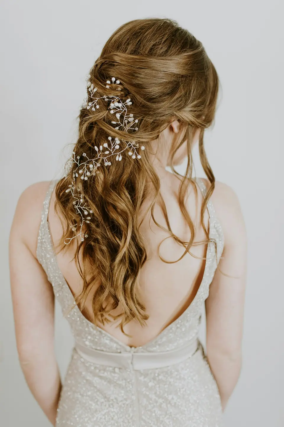 Soft half-up waves with a delicate hair vine, seen from behind