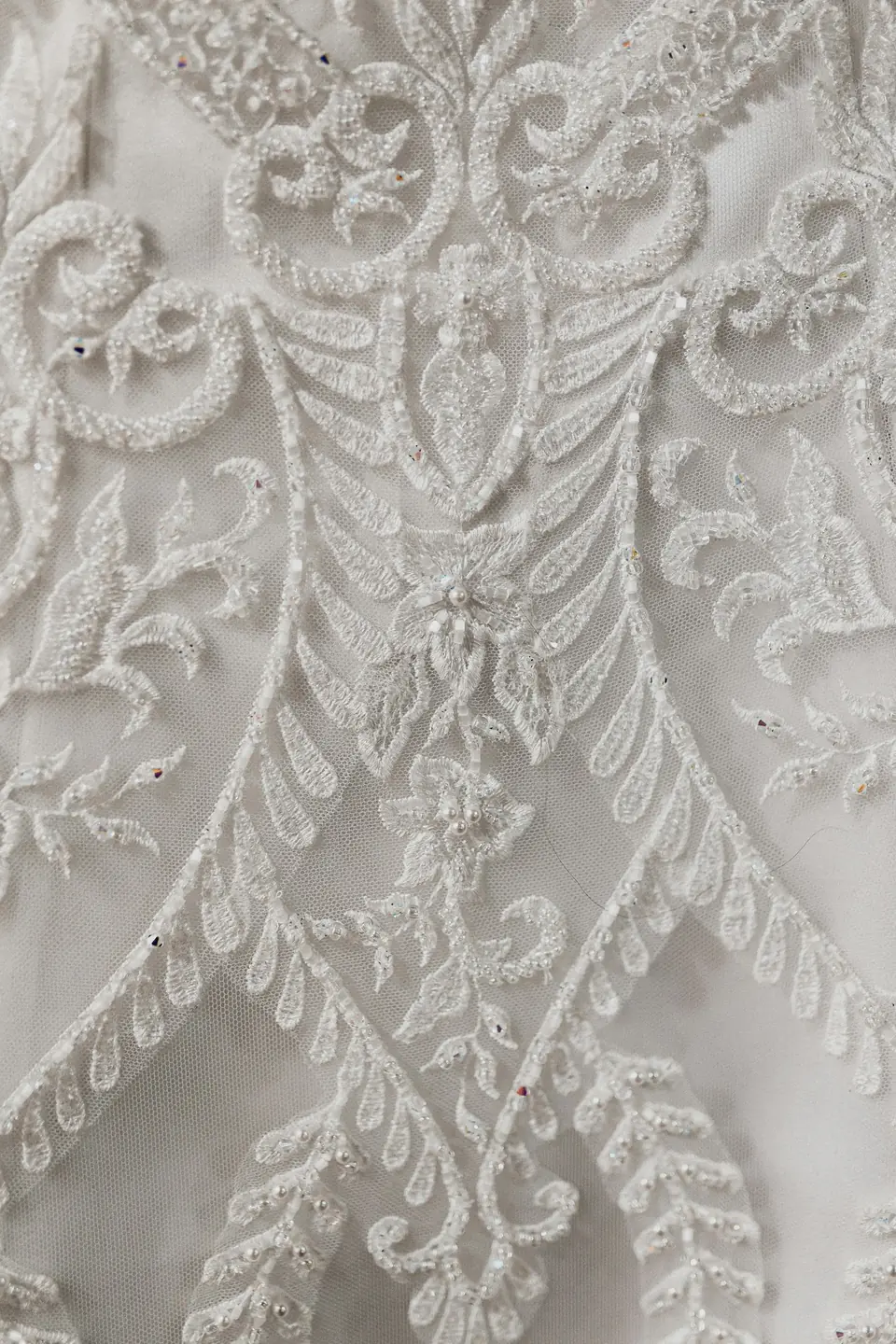 Close-up of beaded lace embroidery on a wedding dress