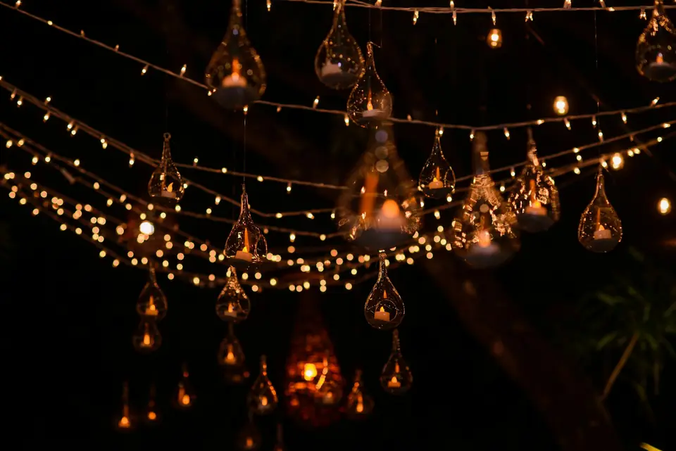 Glass lanterns and string lights hanging over a reception