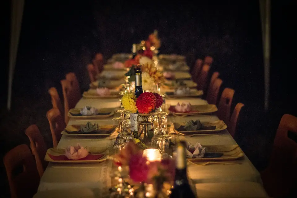 A long candlelit reception table in a dark room
