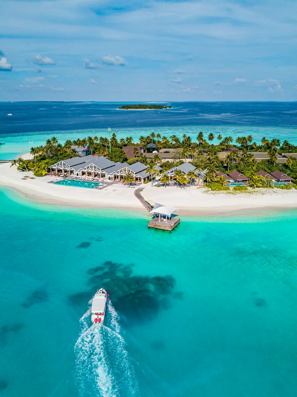 An island resort with overwater villas seen from above