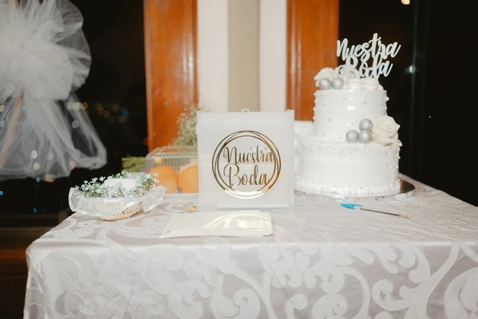 A wedding cake surrounded by table decorations