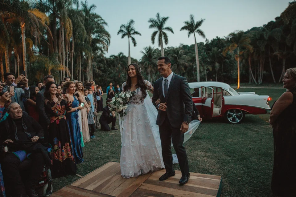 A newly married couple walking together among their wedding guests