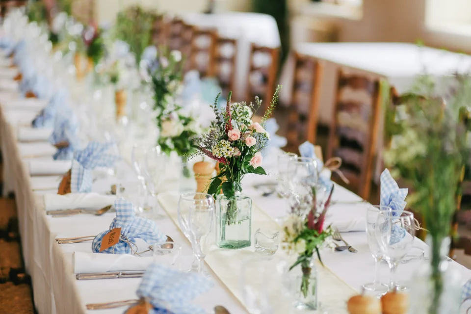 A wedding reception table set with flowers and glassware