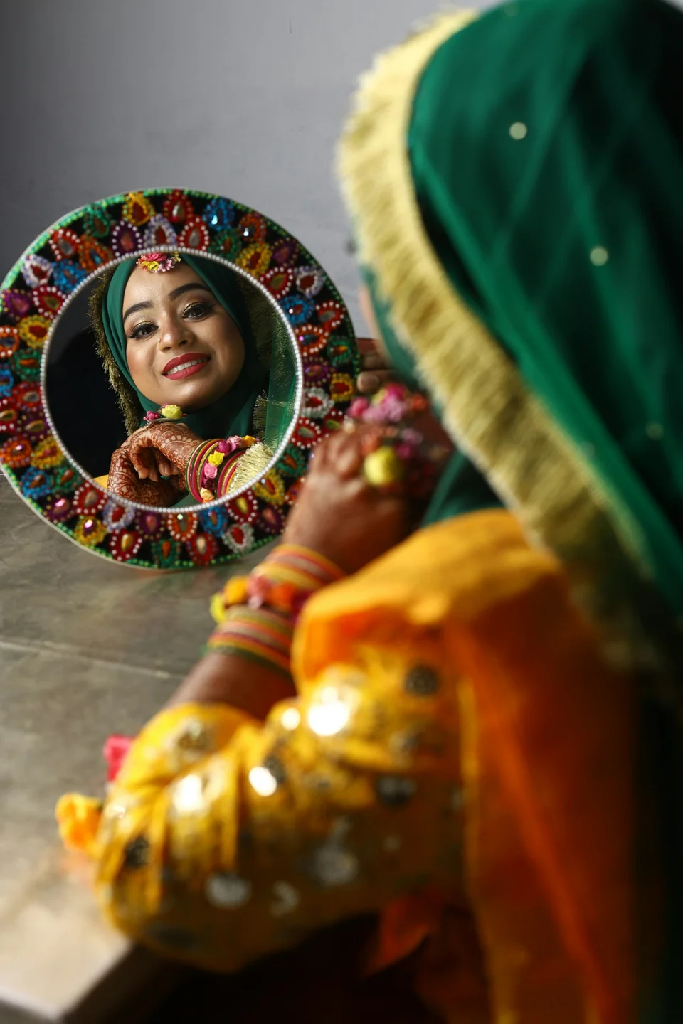 A bride looking in an ornate mirror during her wedding preparations