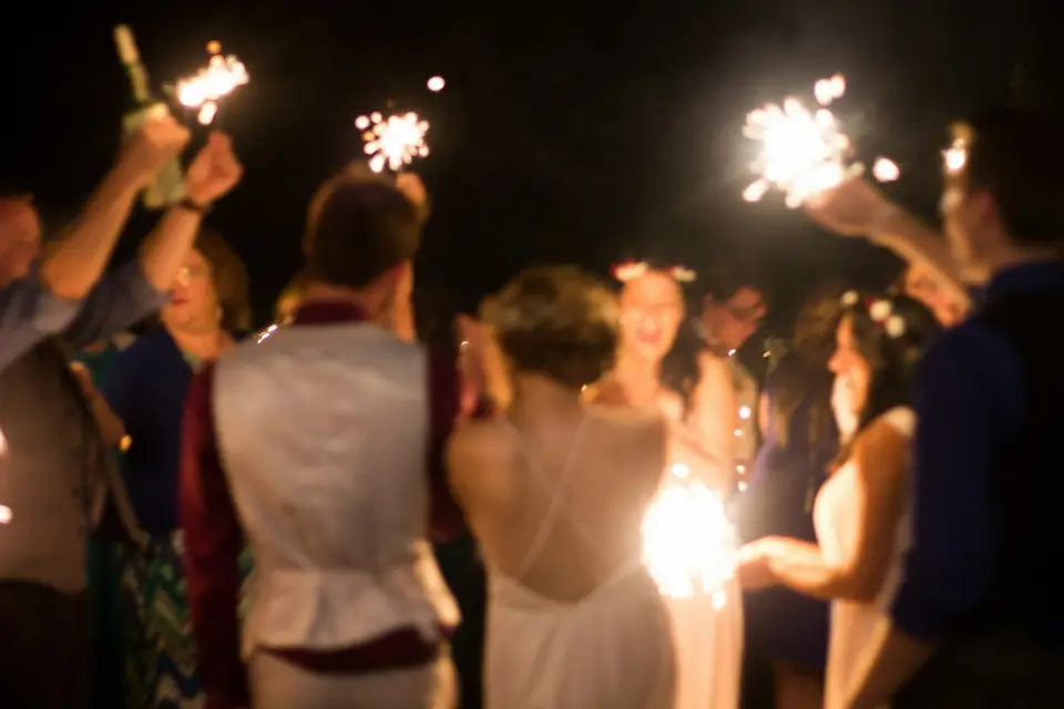 Guests holding sparklers as the couple leaves the reception