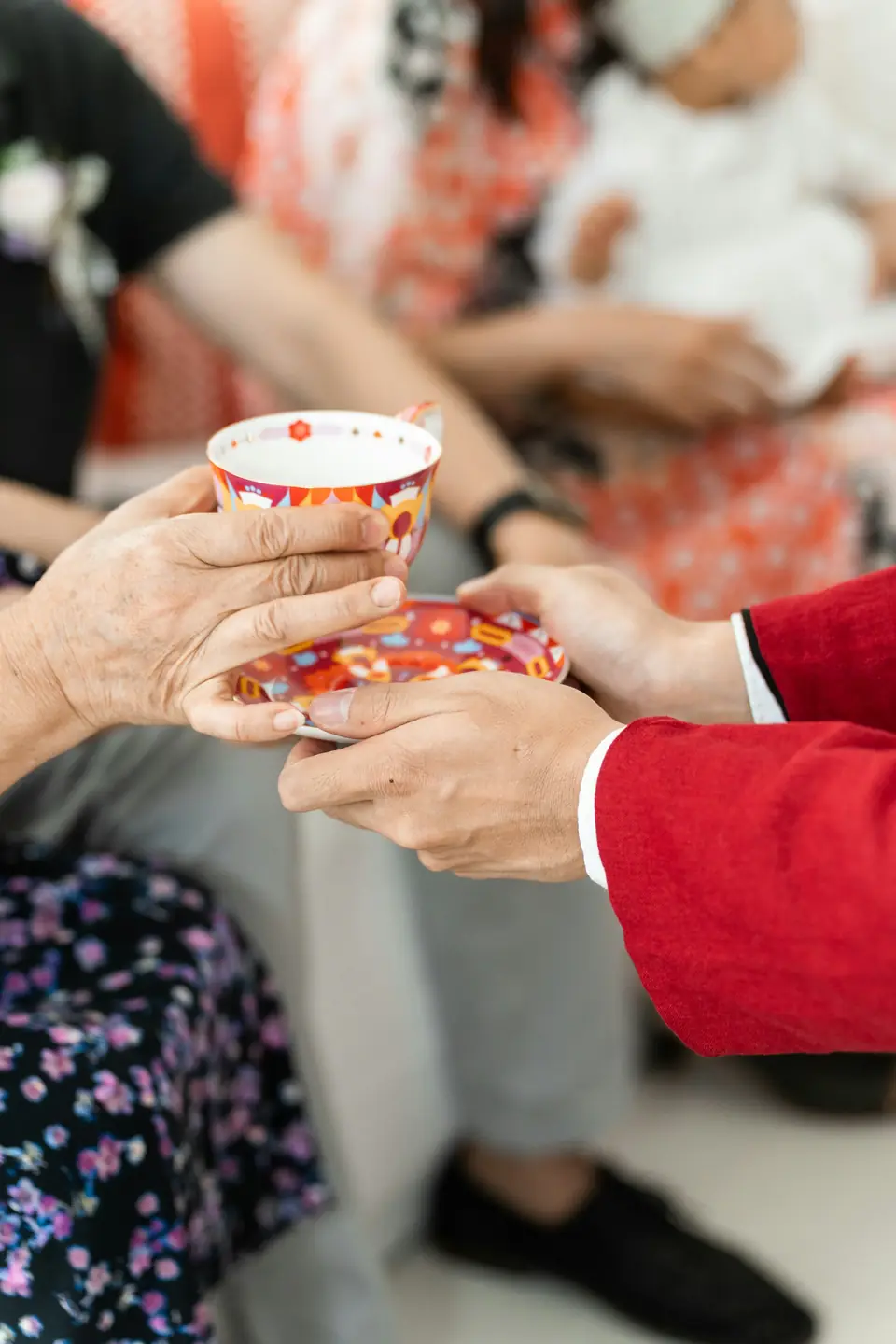 A couple serving tea to an elder during a traditional tea ceremony