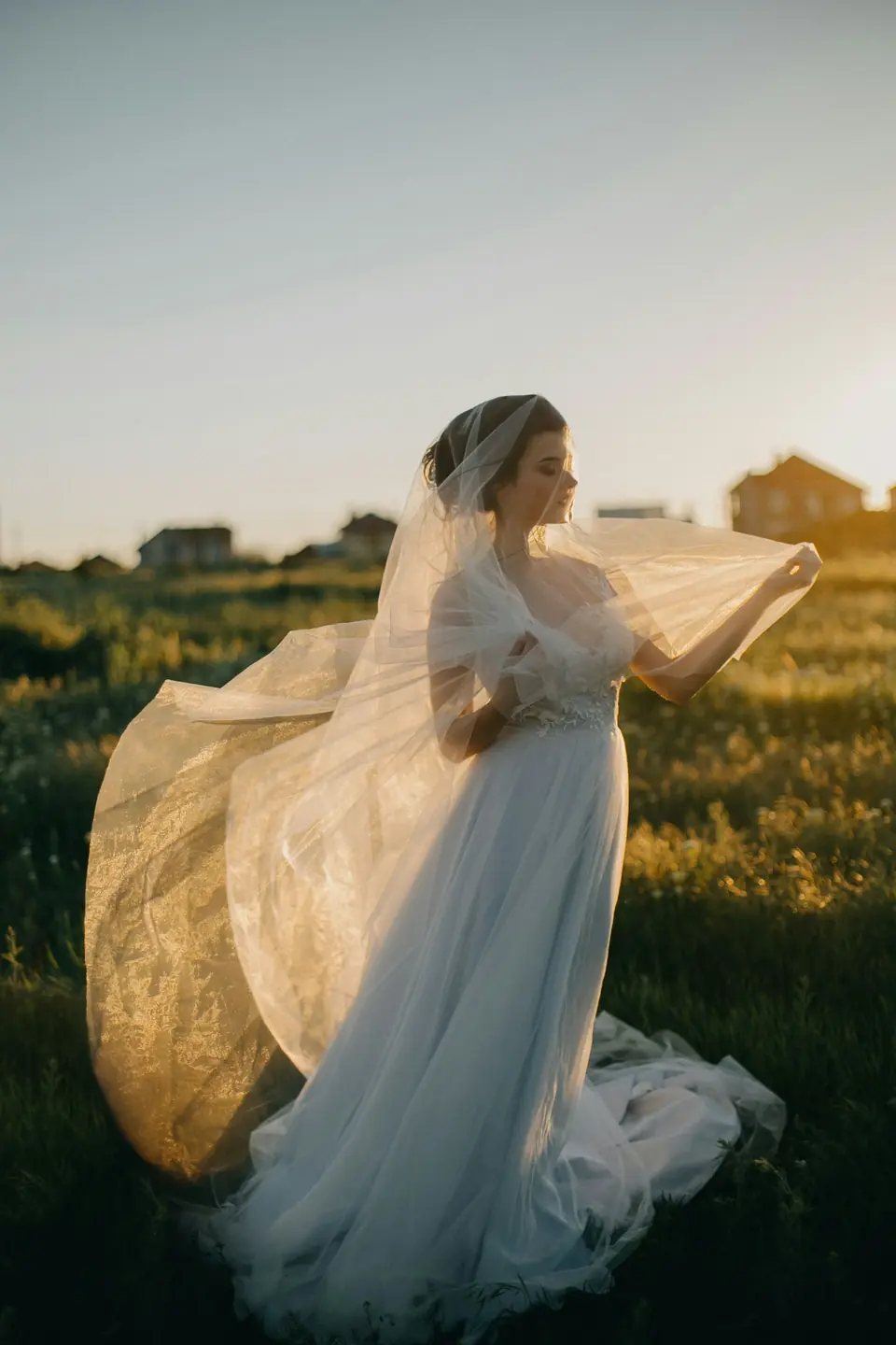 A bride's veil catching the wind in golden evening light